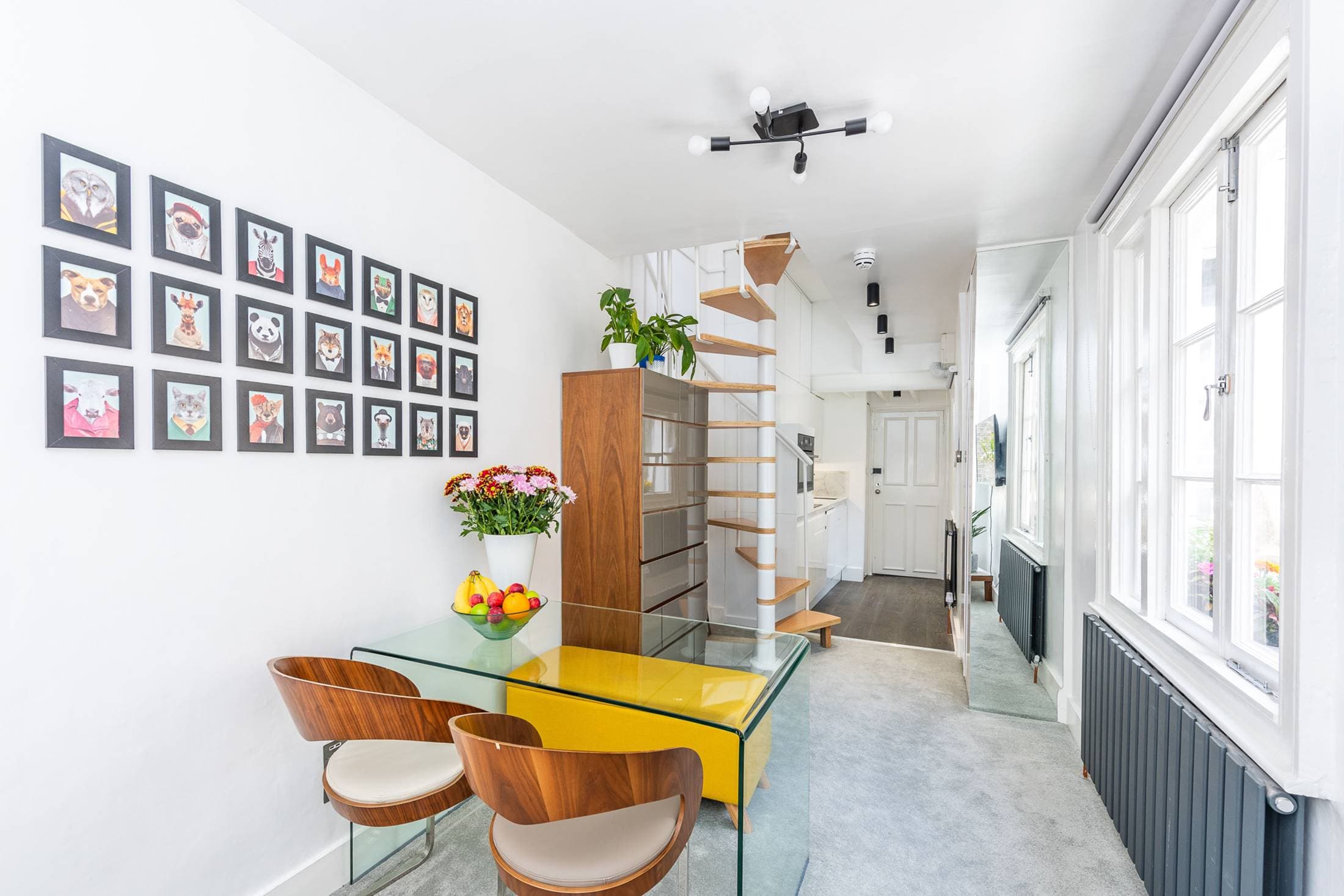 Dining area for four with modern table and velvet couch behind