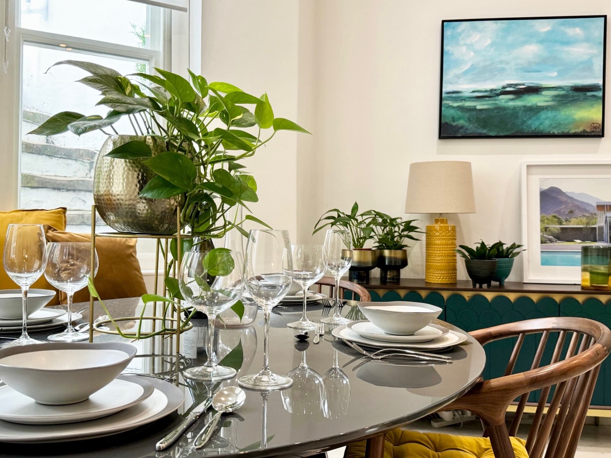 Dining area with marble table seating six and statement pendant lighting
