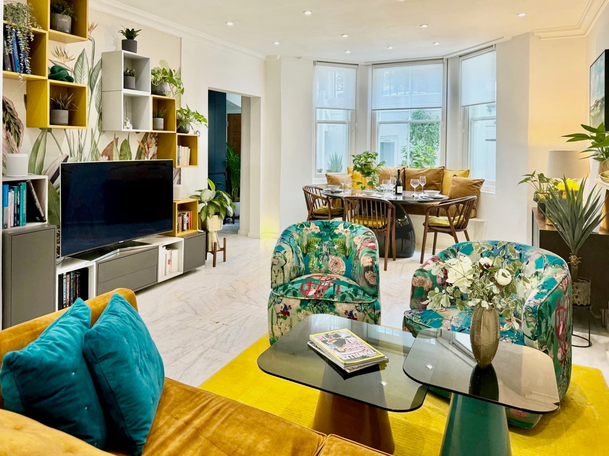 Living room with velvet sofa, art and natural light from the back garden
